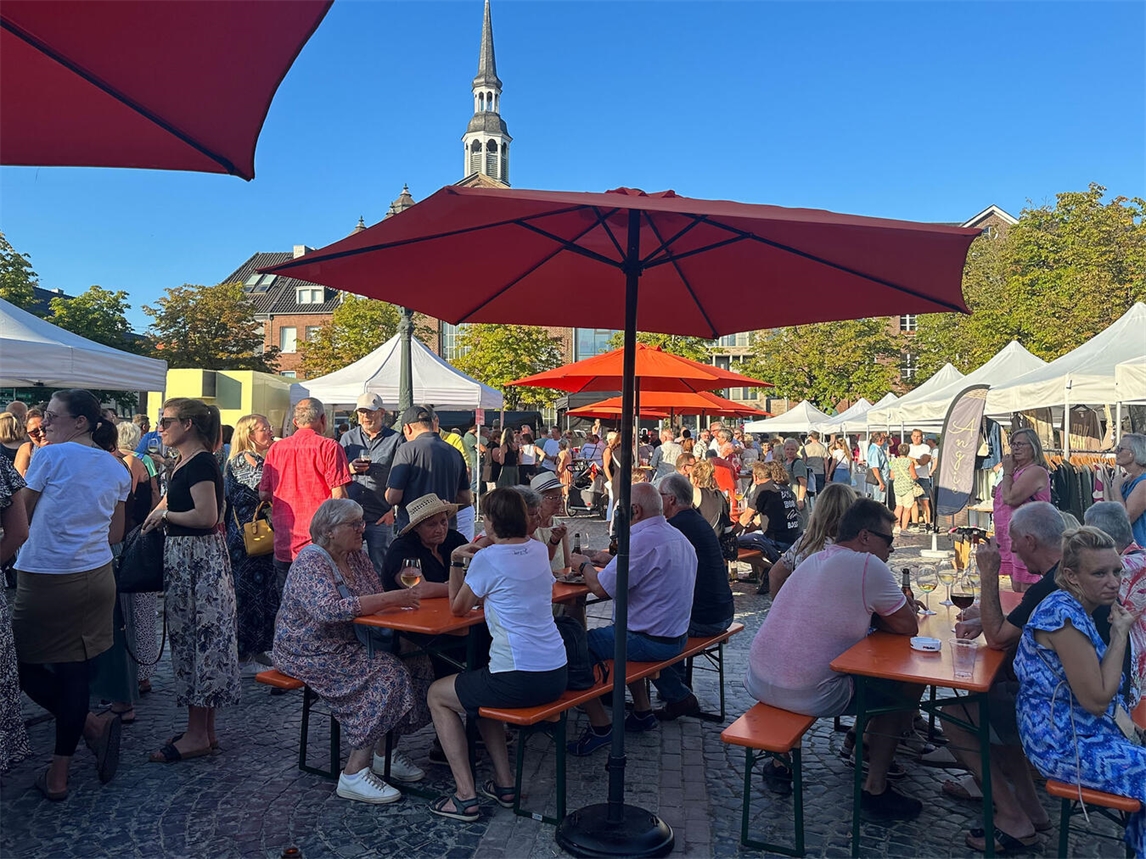 "Feierabendmarkt in Goch mit Menschen, Ständen und Lichtern bei Dämmerung, Foto von Marie-Christin Rohnke"