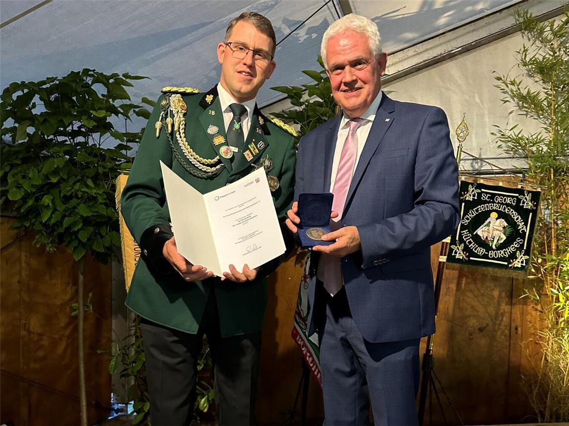 Feierstunde: Dr. Günther Bergmann und Brudermeister Markus Holtkamp bei der Übergabe von Urkunde und Ehrenplakette. Foto: Lörks