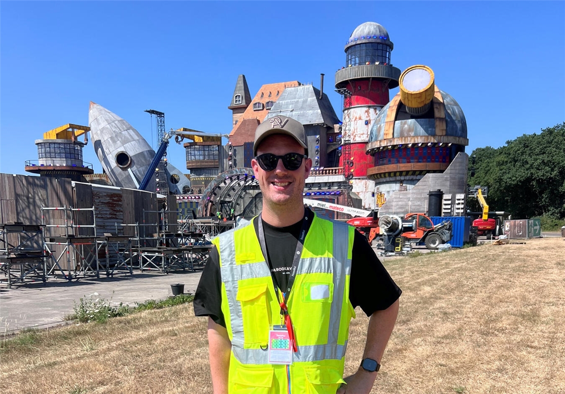 "Bernd Dicks präsentiert Festival-Neuheiten vor der Bühne Bill's Factory mit neuem Leuchtturm im Hintergrund."