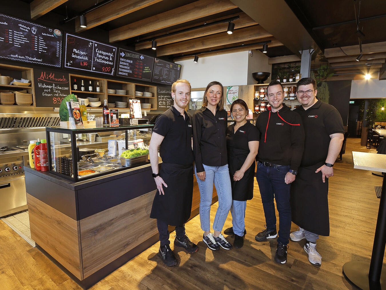 Filialleiter Björn Olfen, Verkaufsleiterin Jenny Witt, Mitarbeiterin Melchora Vollmerhaus, Geschäftsführer Daniel Quartier und Mitarbeiter Danny Wirtz (v.l.) in der neu eröffneten CurryQ-Filliale in Xanten. NN-Foto: Theo Leie