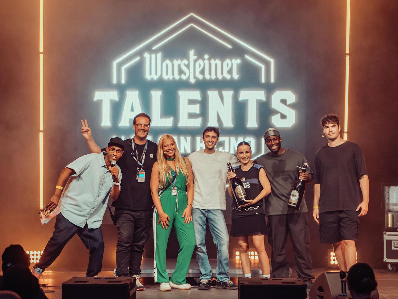 Finale in San Hejmo: (v.l.n.r.) Moderator Amiaz Habtu, Festivalgründer Bernd Dicks, Nadja Gärtner von Warsteiner, TOSHA und Team sowie Leander Kirschner, Gründer von Bamboo Artists (r.).Foto: Jonathan Braasch