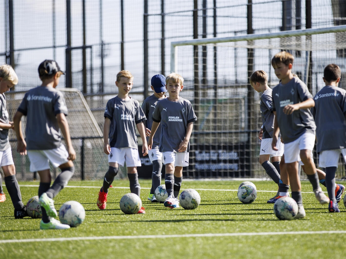 "Fohlen Academy Feriencamp 2025 im Borussia Park, spielende Kinder auf dem Fußballfeld"