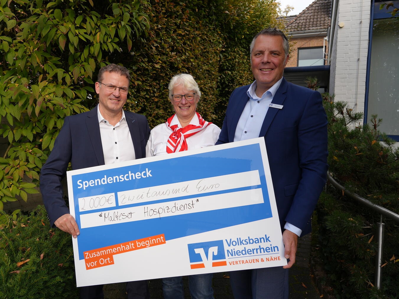 Frank Linßen (l.) und Timm Enters (r.) von der Volksbank überreichten Martina Zimmer den Scheck. Foto: Volksbank Niederrhein