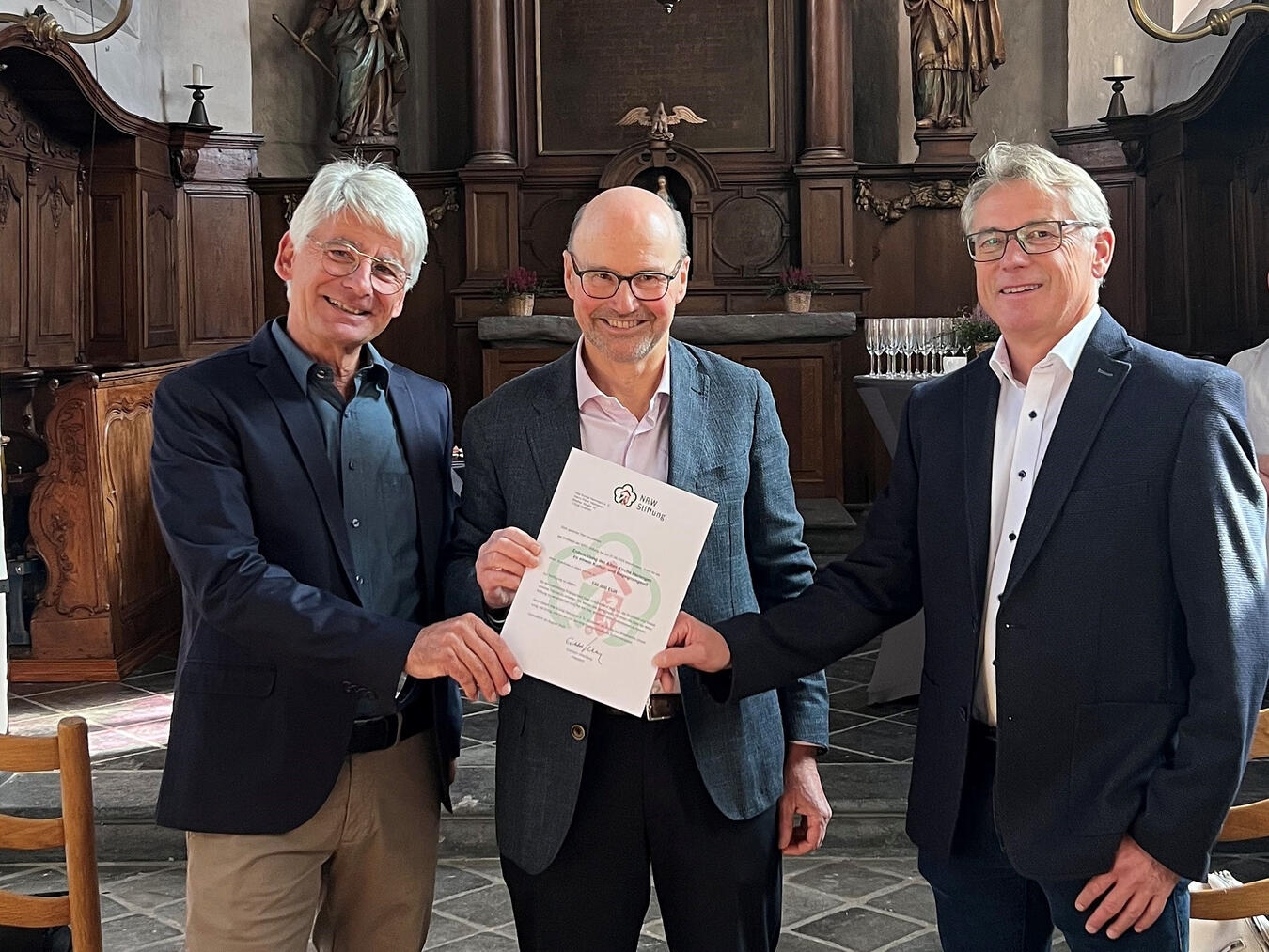 NRW-Stiftung fördert Umbau mit bis zu 100.000 Euro Franz-Josef Lersch-Mense, Vorstandsmitglied der NRW-Stiftung, überreicht die Förderurkunde an den 1. Vorsitzenden Norbert Holzweiler (l.) und den 2.Vorsitzenden Peter Heykamps (r.).