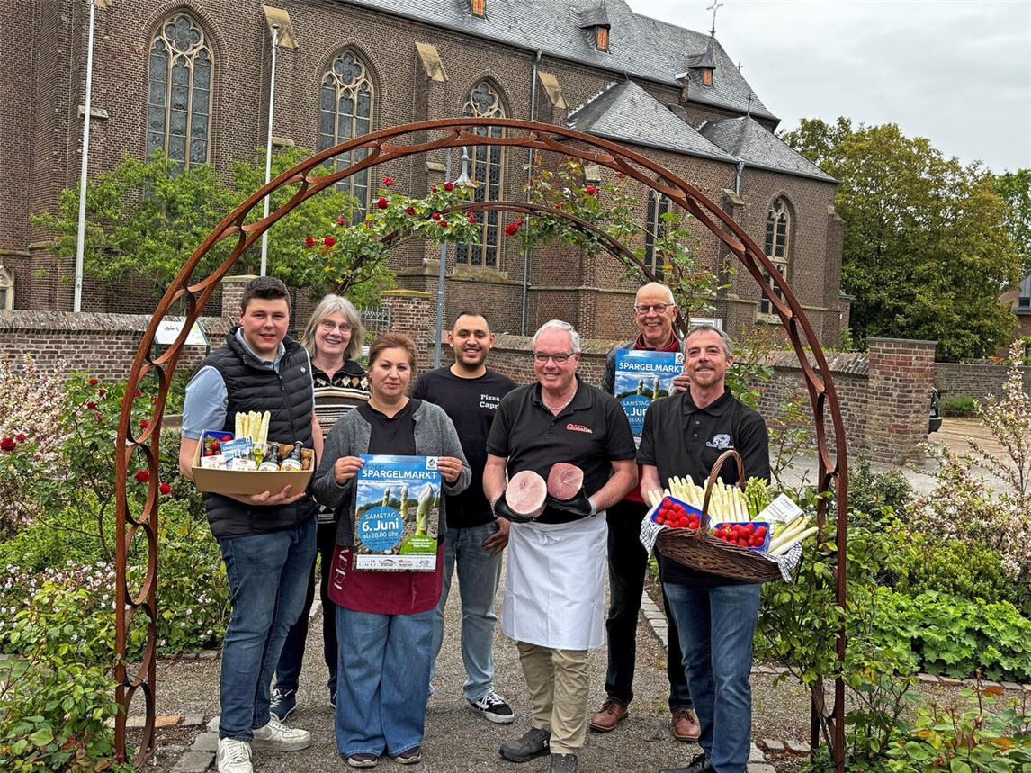 Gruppe von Gastronomen und Veranstaltern lächelt auf dem Spargelmarkt, darunter Lukas Ophey und Irmgard Kruse.