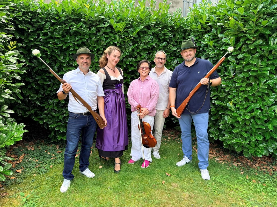Menschen lächeln bei einer Veranstaltung in Geldern, darunter Musikerin mit Viola; Sparkasse Krefeld unterstützt.