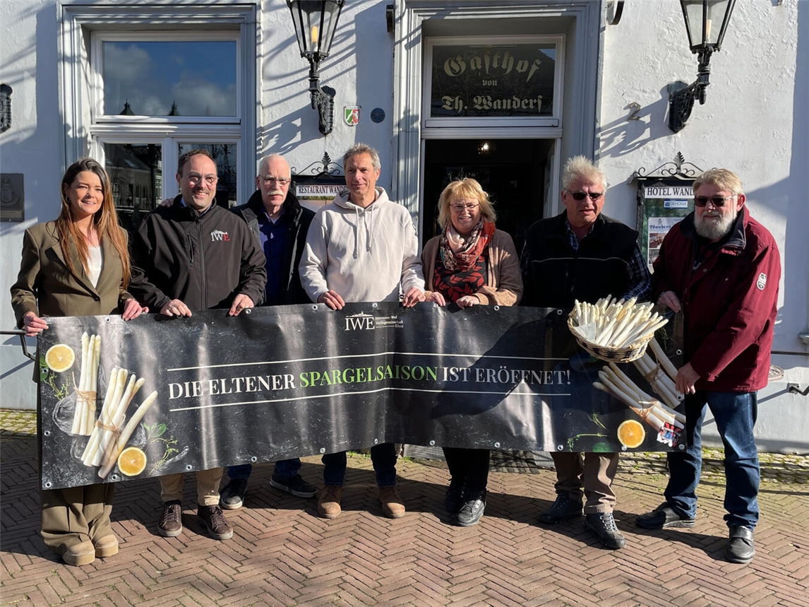 Gruppenfoto der „Arbeitsgemeinschaft Eltener Spargel“ mit großem Banner und Spargelkorb