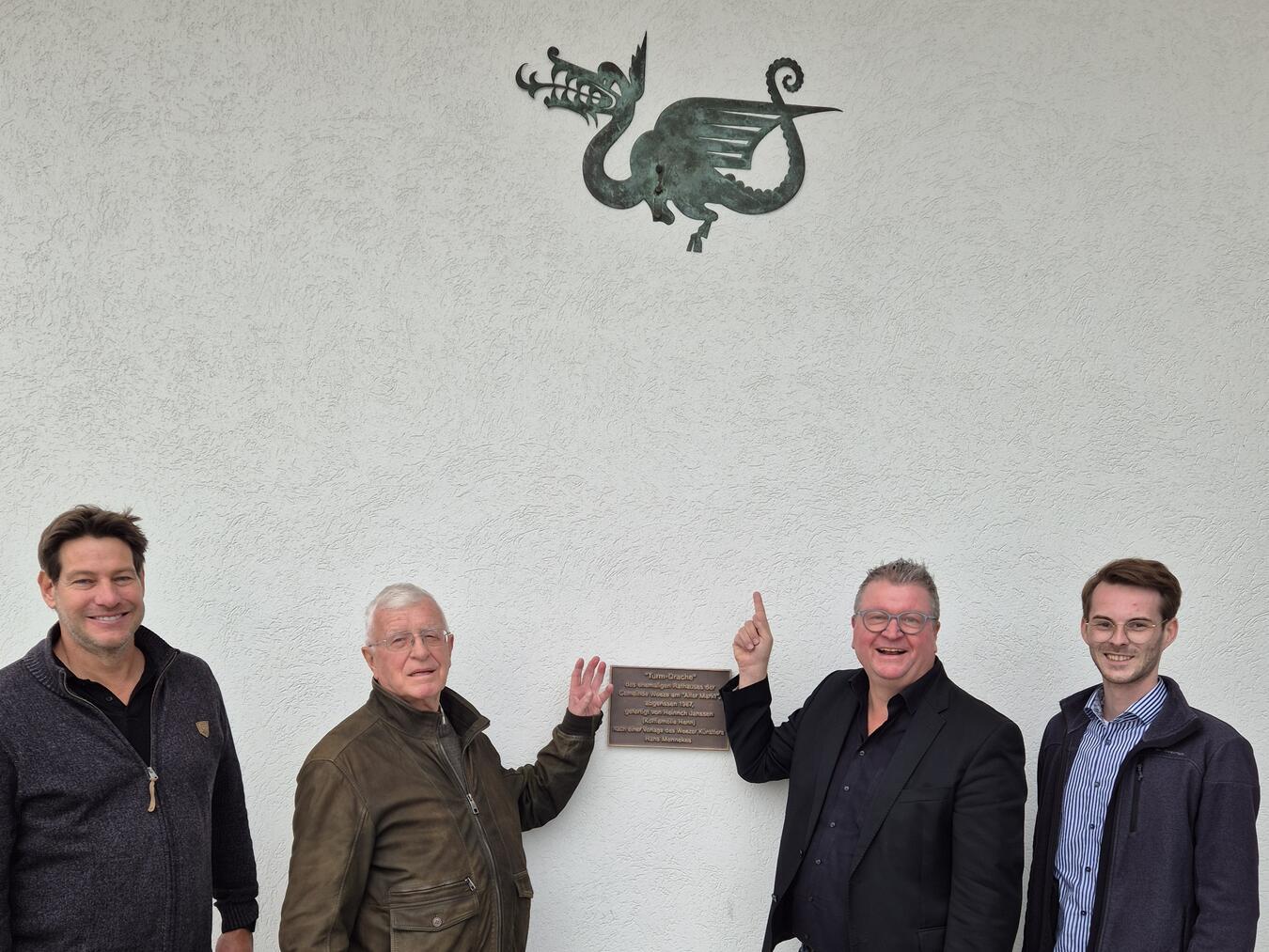 Freuen sich, dass der Drache einen neuen Platz gefunden hat (v.l.): Fachbereichsleiter Jugend, Senioren, Kultur und Tourismus Volker Schoelen, Egon Hünnekens, Bürgermeister Georg Koenen und der Leiter des Büros für Kultur und Tourismus Jonathan Brauer. Foto: Gemeinde Weeze