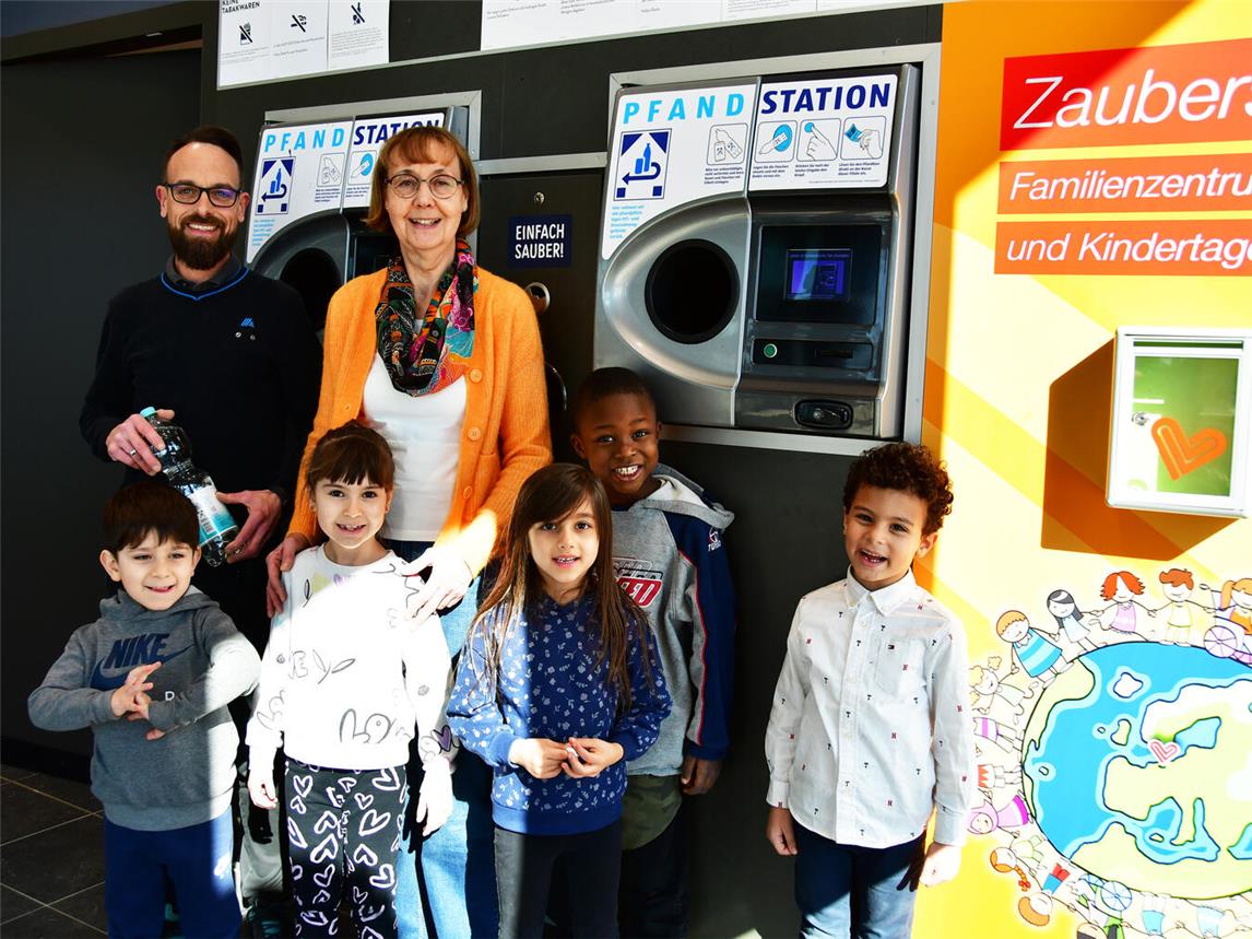 Freuen sich über die neue Pfandbon-Spendenbox im Aldi-Markt an der Querallee in Materborn: Aldi-Filialleiter Jürgen Wolters und Siegrid Schüßler, Leiterin der Caritas-Kindertagesstätte Zauberstern, mit den Kindern Amir, Mia, Amila, Yusuf und Ramzi. Foto: Caritas