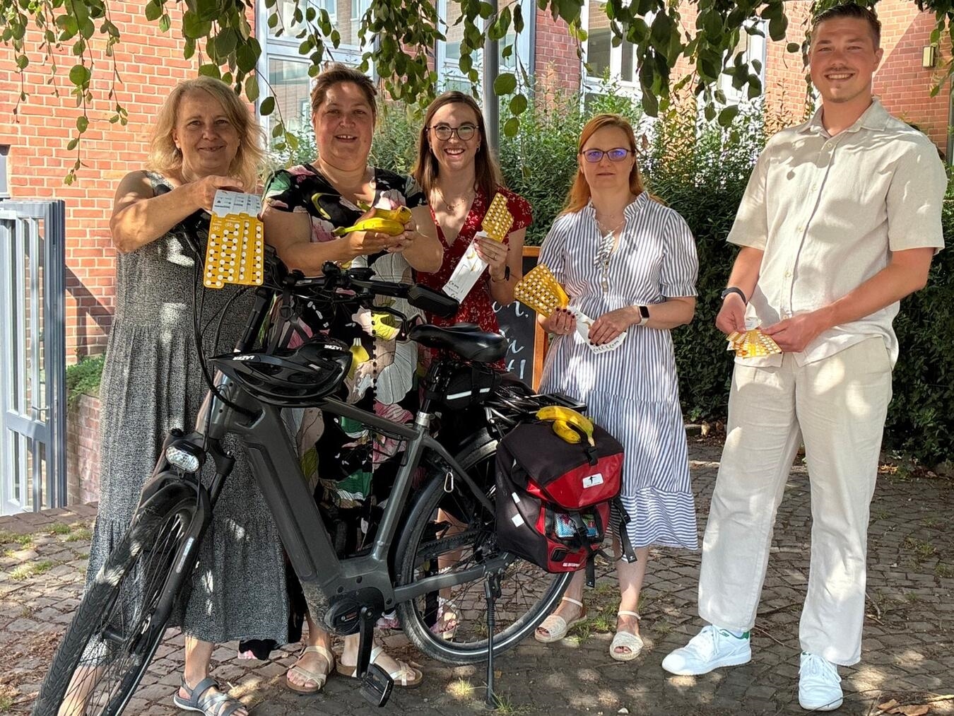Gruppe von fünf Personen feiert neue Radroute in Kleve, mit farbigen Lenkerbändern, darunter Vertreter von Wirtschaft und Tourismus.
