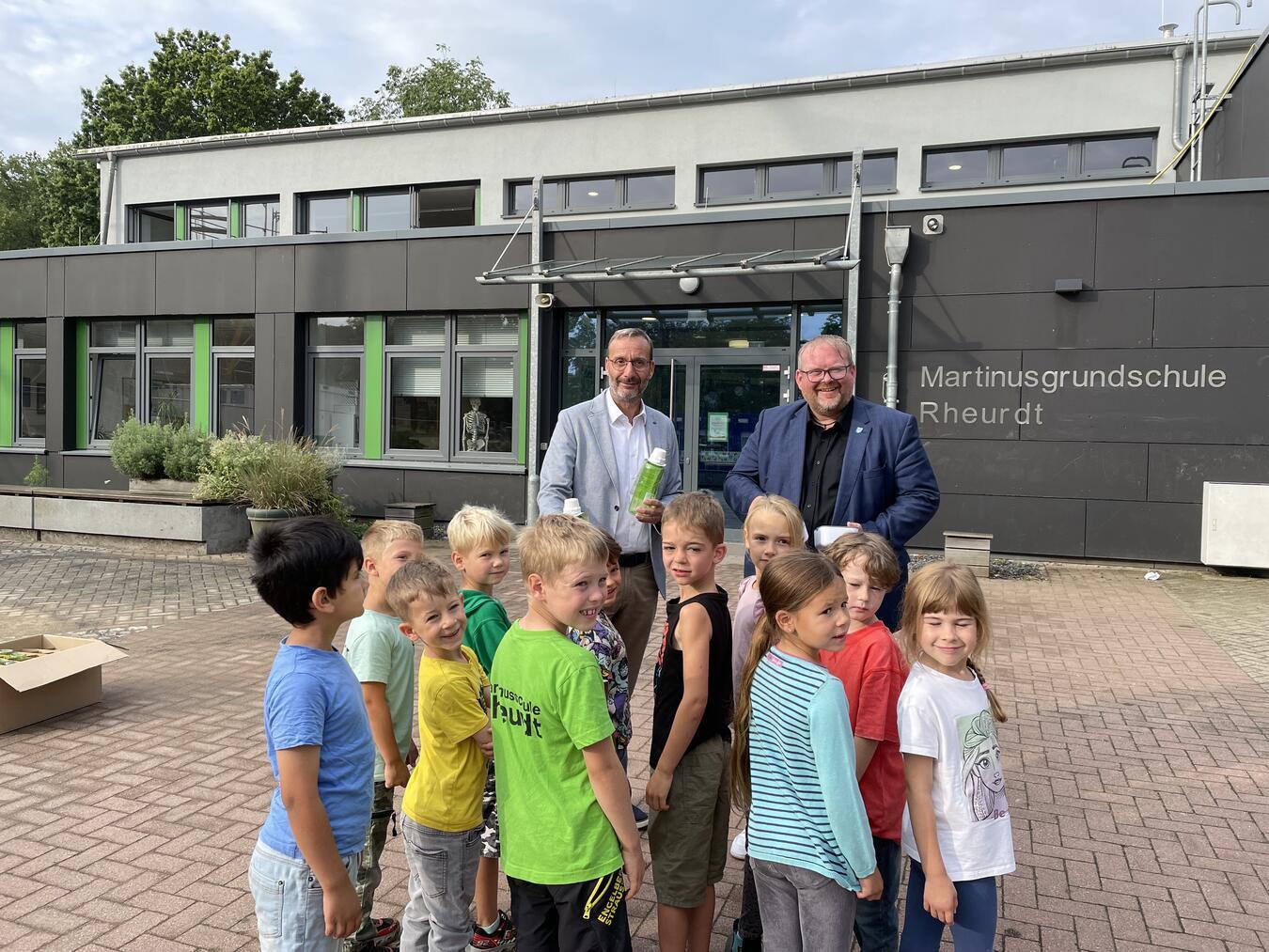 Nachhaltige Überraschung für 48 Erstklässler in Rheurdt Frithjof Gerstner (l.), Westenergie-Kommunalmanager, und Bürgermeister Dirk Ketelaers (r.) bei der Übergabe der Westenergie Trinkflaschen an die 48 Erstklässler. Foto: Westenergie AG