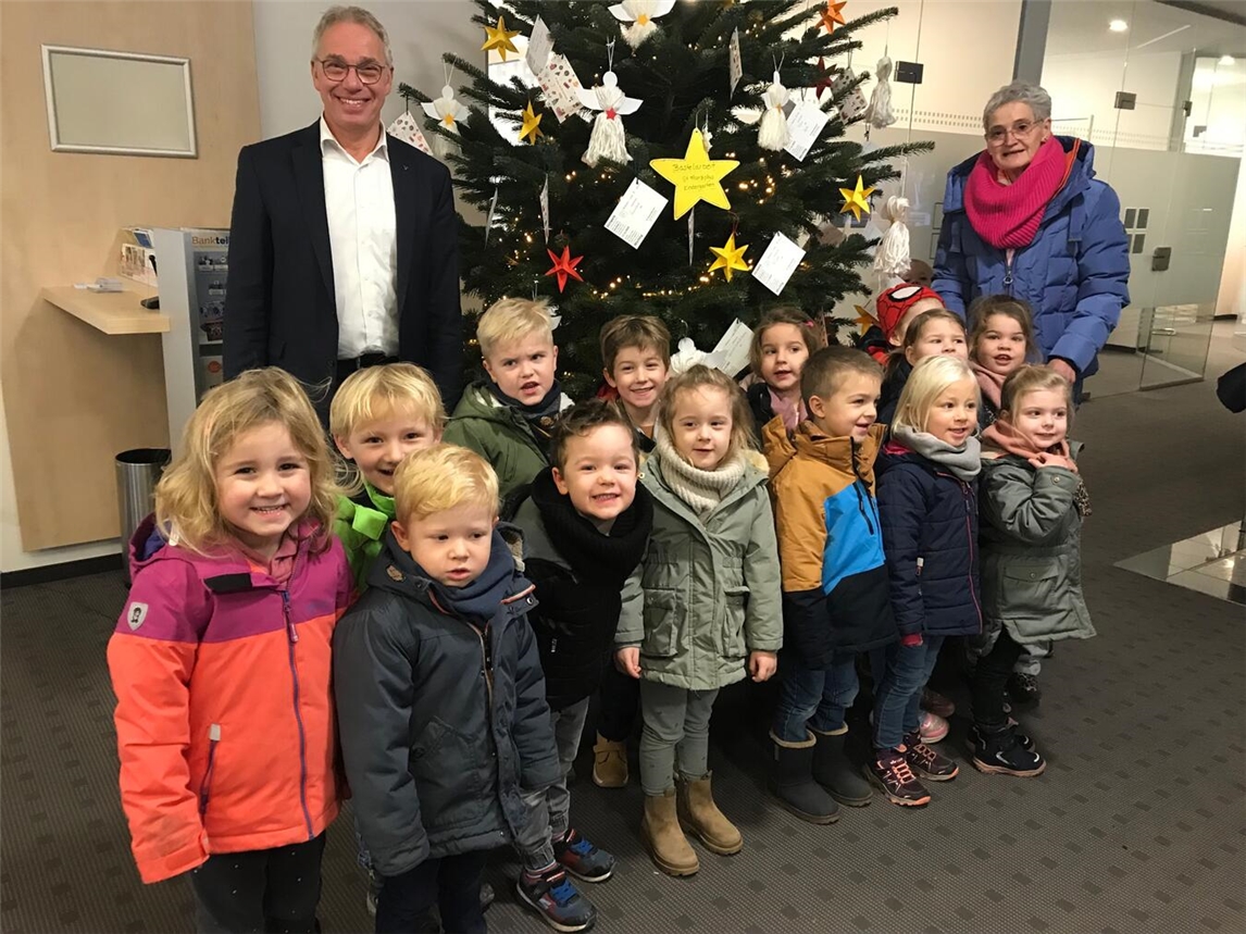Fröhliche Kinder der Kita St. Franziskus, eingerahmt von der Erzieherin Maria Schmitz (r.) und dem Geschäftsstellenleiter der Volksbank, Franz Steenmans. Foto: privat