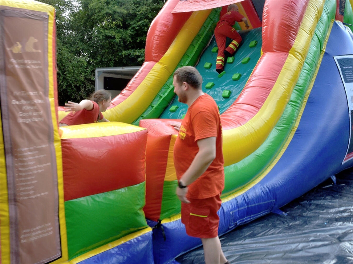 "Überdimensionale Hüpfburg und Kettcar-Parcours der DLRG für Kinder bei Event"