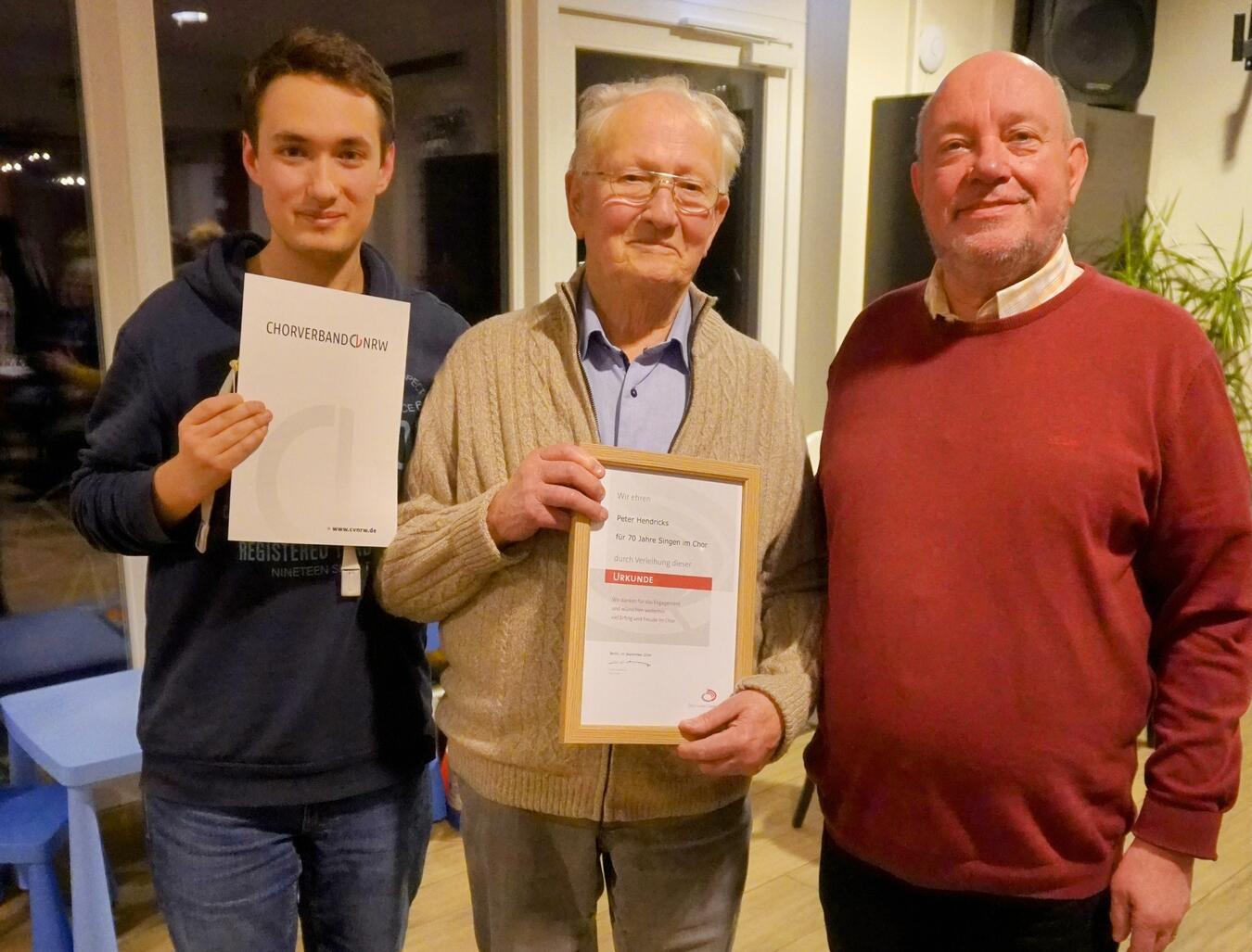 Für seine 70jährige Mitgliedschaft in den Weezer Voices ehrten Paul-Erik Meyn (Vorsitzender des Sängerkreis Wesel, l.), und Manfred Tissen (Vorsitzender Weezer Voices, r.) das Mitglied Peter Hendricks (m.).