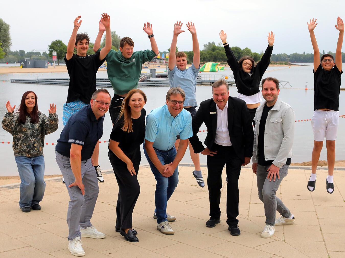 FZX-Geschäftsführung Thomas Görtz, Bürgermeister der Stadt Xanten, Tatjana Maurer und Ralf Berensmeier, Sparkassen-Geschäftsstellenleiter Ludger Wehren, FZX-Leiter Ludwig Ingenlath; die Kids: Mahmoud, Elif, Louis, Lara, Mariam und Hannes freuen sich über das kostenfreie Ferienschwimmen-Angebot. Foto: FZX