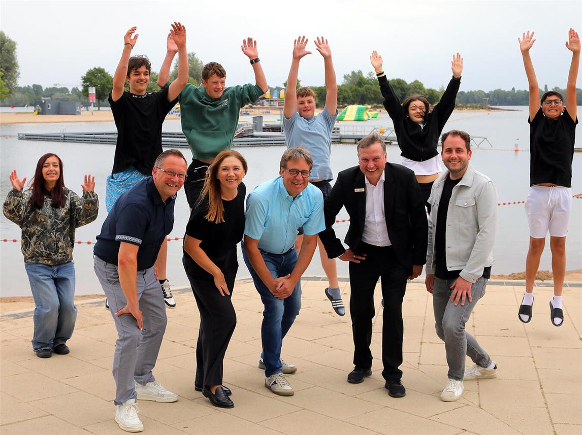 FZX-Geschäftsführung Thomas Görtz, Bürgermeister der Stadt Xanten, Tatjana Maurer und Ralf Berensmeier, Sparkassen-Geschäftsstellenleiter Ludger Wehren, FZX-Leiter Ludwig Ingenlath; die Kids: Mahmoud, Elif, Louis, Lara, Mariam und Hannes freuen sich über das kostenfreie Ferienschwimmen-Angebot. Foto: FZX