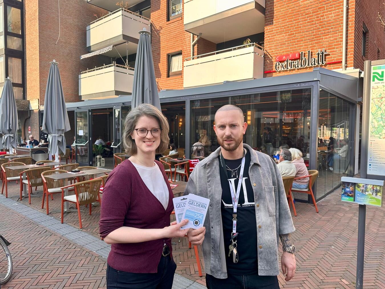 Cafe Extrablatt wird Akzeptanzstelle für Gelderner Stadtgutschein, Citymanagerin und Geschäftsführer Dennis Blazevic freuen sich.