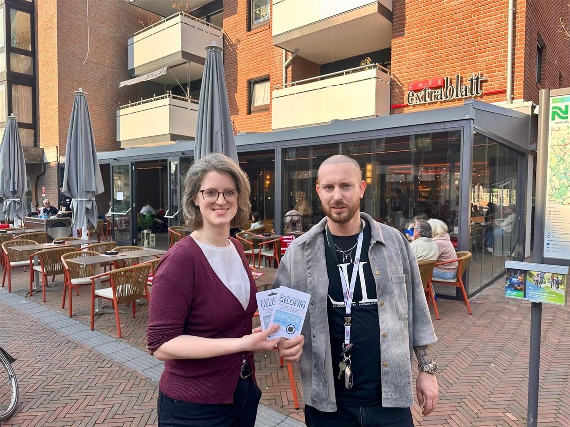Cafe Extrablatt wird Akzeptanzstelle für Gelderner Stadtgutschein, Citymanagerin und Geschäftsführer Dennis Blazevic freuen sich.