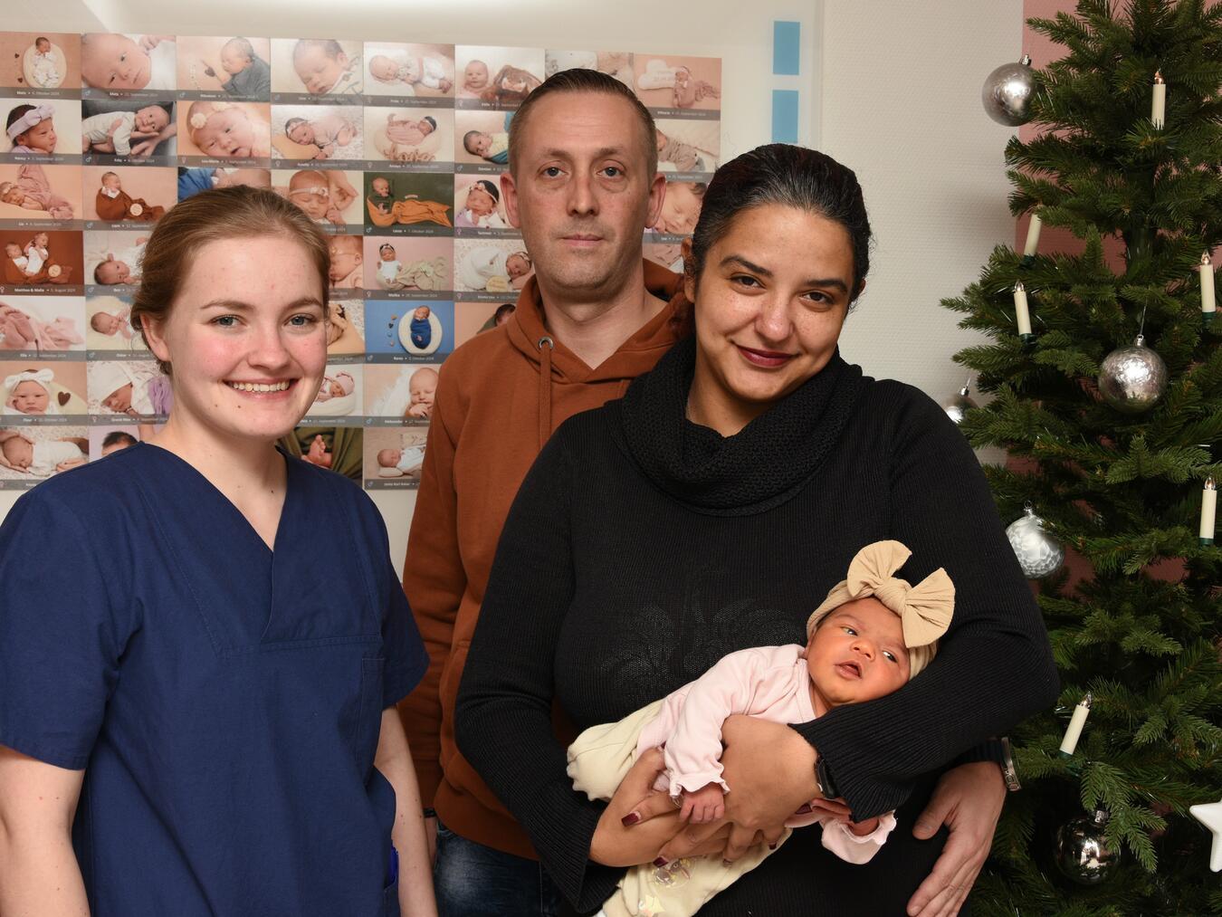 Gemeinsam mit Kira und den frischgebackenen Eltern freut sich auf dem Foto Hebamme Celine Hendricks. Foto: KKLE / Kristin Bäcker
