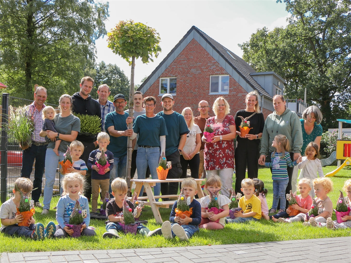 Gemeinsam stark für die Kita Heidezwerge: Gärtner, Kinder, Eltern und Mitarbeitende freuen sich über die neuen Pflanzen und die Sitzgruppe.Foto: Caritasverband Geldern-Kevelaer