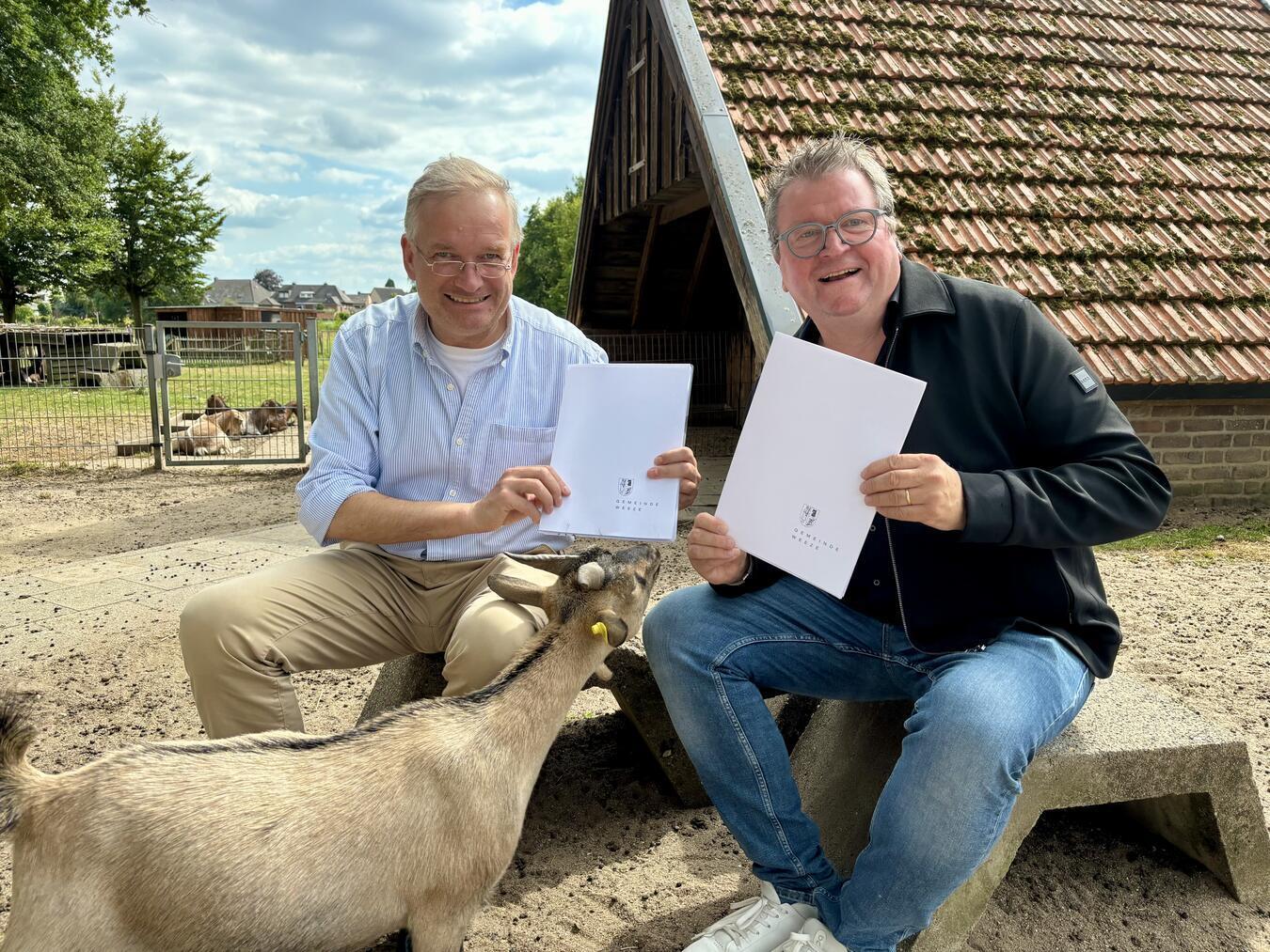 Graf Friedrich zu Eulenburg und Hertefeld (l.) und Weezes Bürgermeister Georg Koenen (r.) freuen sich gemeinsam mit den vierbeinigen Bewohnern des Tierparks über den verlängerten Pachtvertrag. Foto: Gemeinde Weeze
