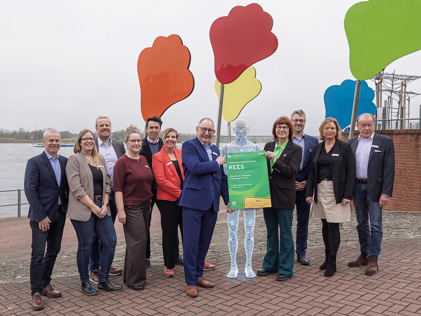 Gruppenfoto mit Roboter (v. l.): Dr. Benedikt Rösen, Irina Janßen, Ole Engfeld, Annette Kook, Ingo Prang, Andrea Franken, Sebastian Hense, Brigitte Jansen, Gerrit Röhl, Martina Furtmann und Dr. Gert George. Foto: WfG Kreis Kleve/Axel Breuer (Foto mit KI bearbeitet)