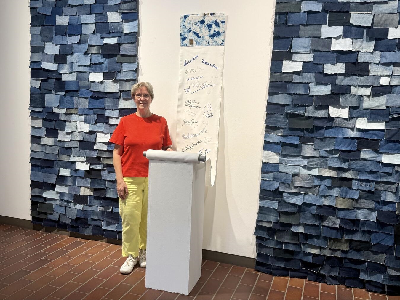 Gudrun Kleffe vor ihrer Installation aus Jeansstoffen, mit der sie die Betrachter dazu anregt, eigene Gedanken zum Thema Jeans festzuhalten. NN-Foto: SP