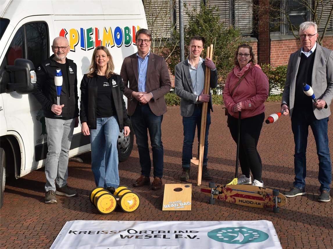 Gustav Hensel, Denise Boymann, Kreisdirektor Ralf Berensmeier, Kai Stegemann und Jennifer Sniegon (beide Jugendarbeit Kreis Wesel) sowie Ulrich Glanz (v.l.) mit einer kleinen Auswahl an Spielgeräten aus dem Spielmobil. Foto: Kreis Wesel