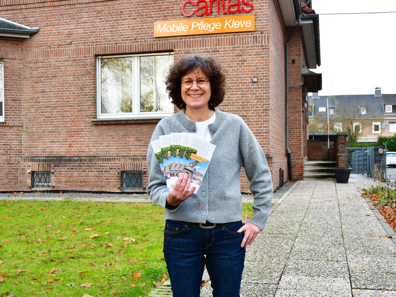 Heike Lippe, Koordinatorin der Caritas-Seniorenreisen, mit den neuen Programmheften. Foto: Caritas