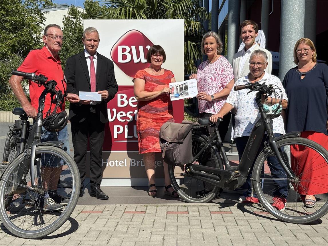 Herzlichen Glückwunsch: Auf Ursula von den Bruck (4.v.r.) wartet ein neues Tourenrad. Herbert Linges (l.), der mit Ehefrau Anita (2.v.r.) nach Brüggen geradelt war, erhielt einen Hotel-Gutschein. Mit ihnen freuten sich (v.l.): René Maludy (Best Western Plus Hotel), Brigitte Odinius (WFG), Matthias Peters (NEW) und Nina Jörgens (NT). Foto: NT