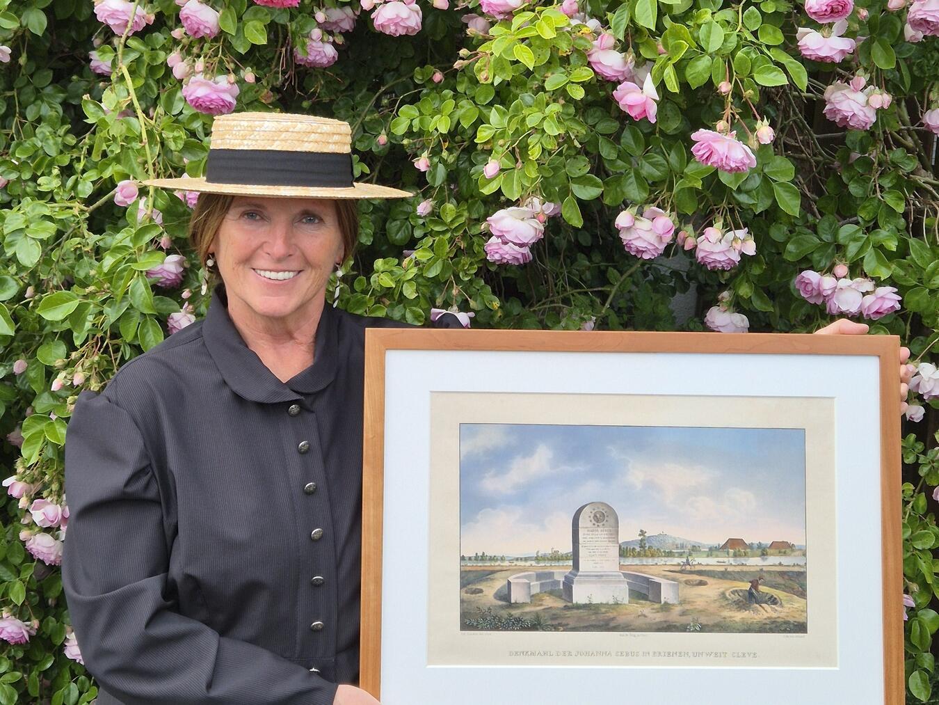Hildegard Liebeton als Madame de Vernejoul zeigt ein Gemälde des Johanna Sebus Denkmals. Foto: WTM