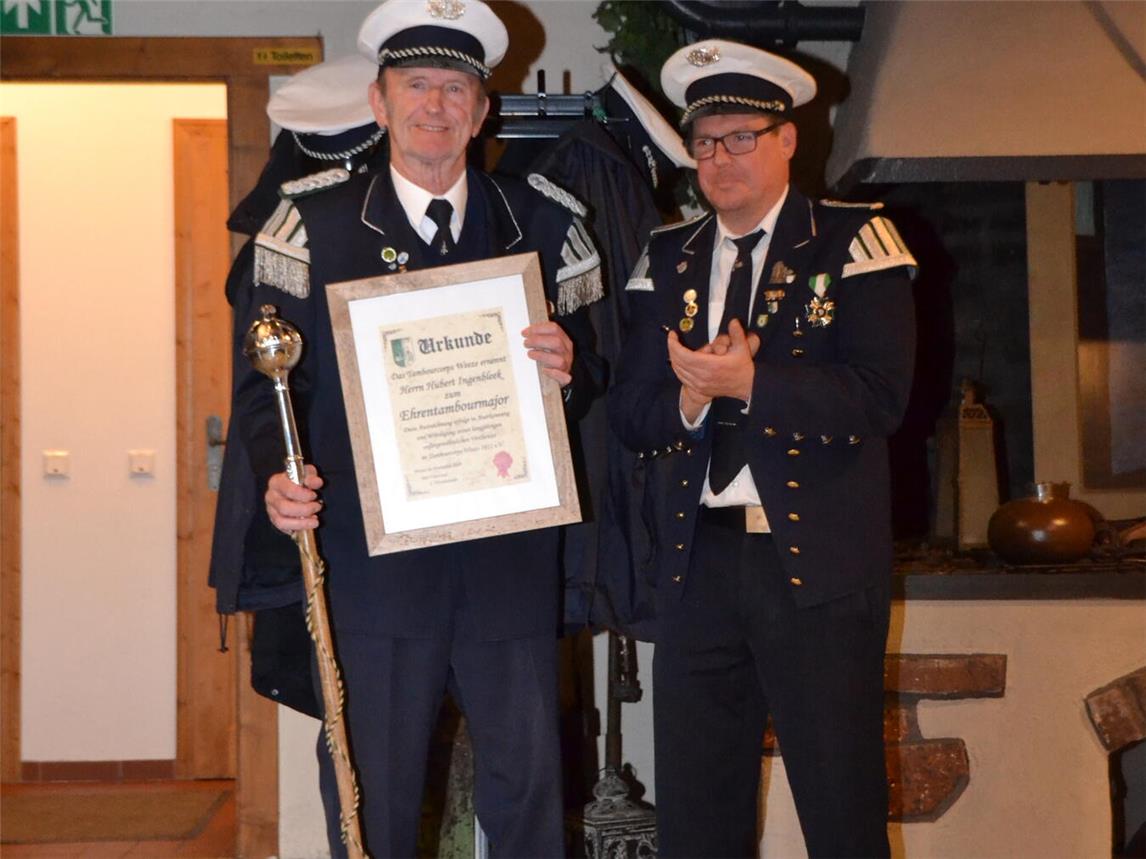 Hubert Ingenbleek (l.) erhält vom 1. Vorsitzenden des des Tambourcorps Weeze Sven Janssen die Ernennungsurkunde zum Ehrentambourmajor. Foto: privat
