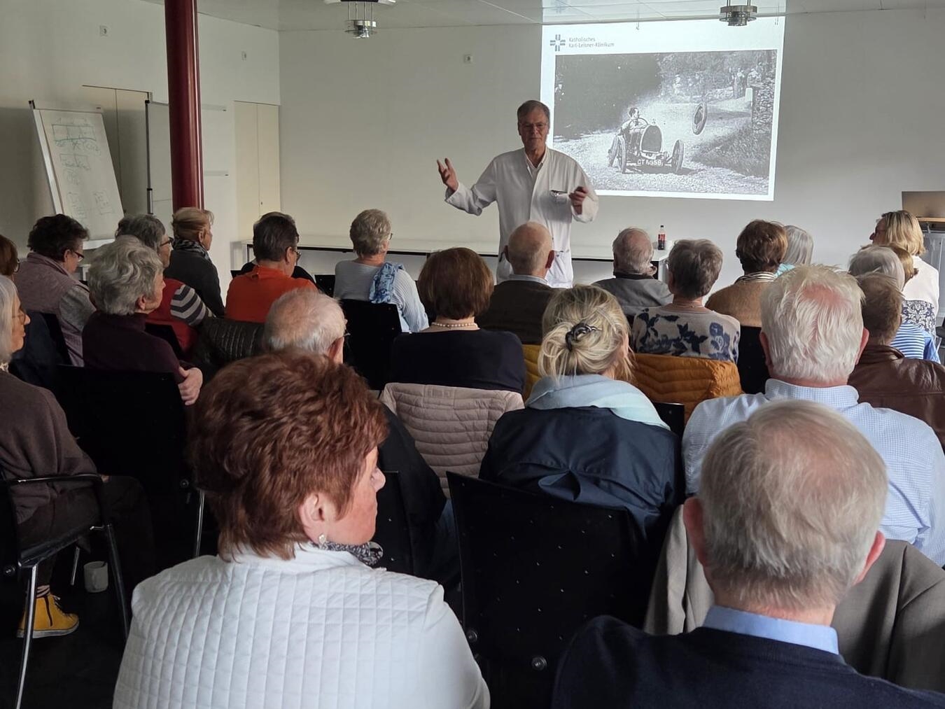 "Dr. Müller beantwortet Fragen der Teilnehmer nach Vortrag, Event, Diskussion, Expertenaustausch"