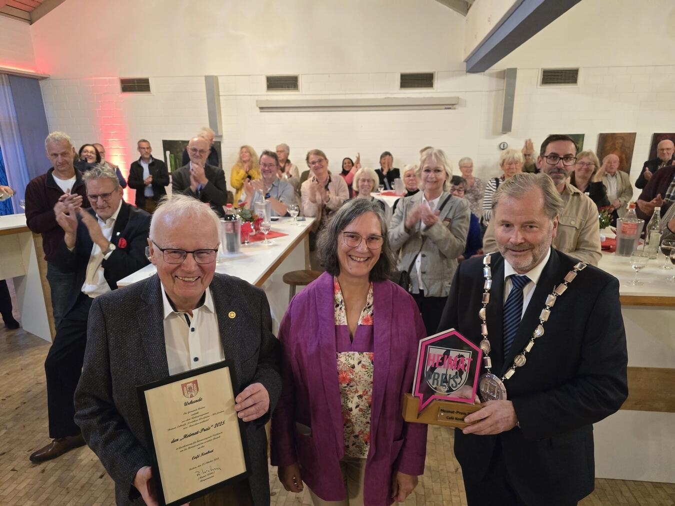 Im Bürgerhaus Uedem wurde die Auszeichnung von Bürgermeister Rainer Weber (r.) an Sujata Davids und Hans-Dieter Kahrl (l.) vom Café Konkret übergeben. NN-Foto: Gerhard Seybert