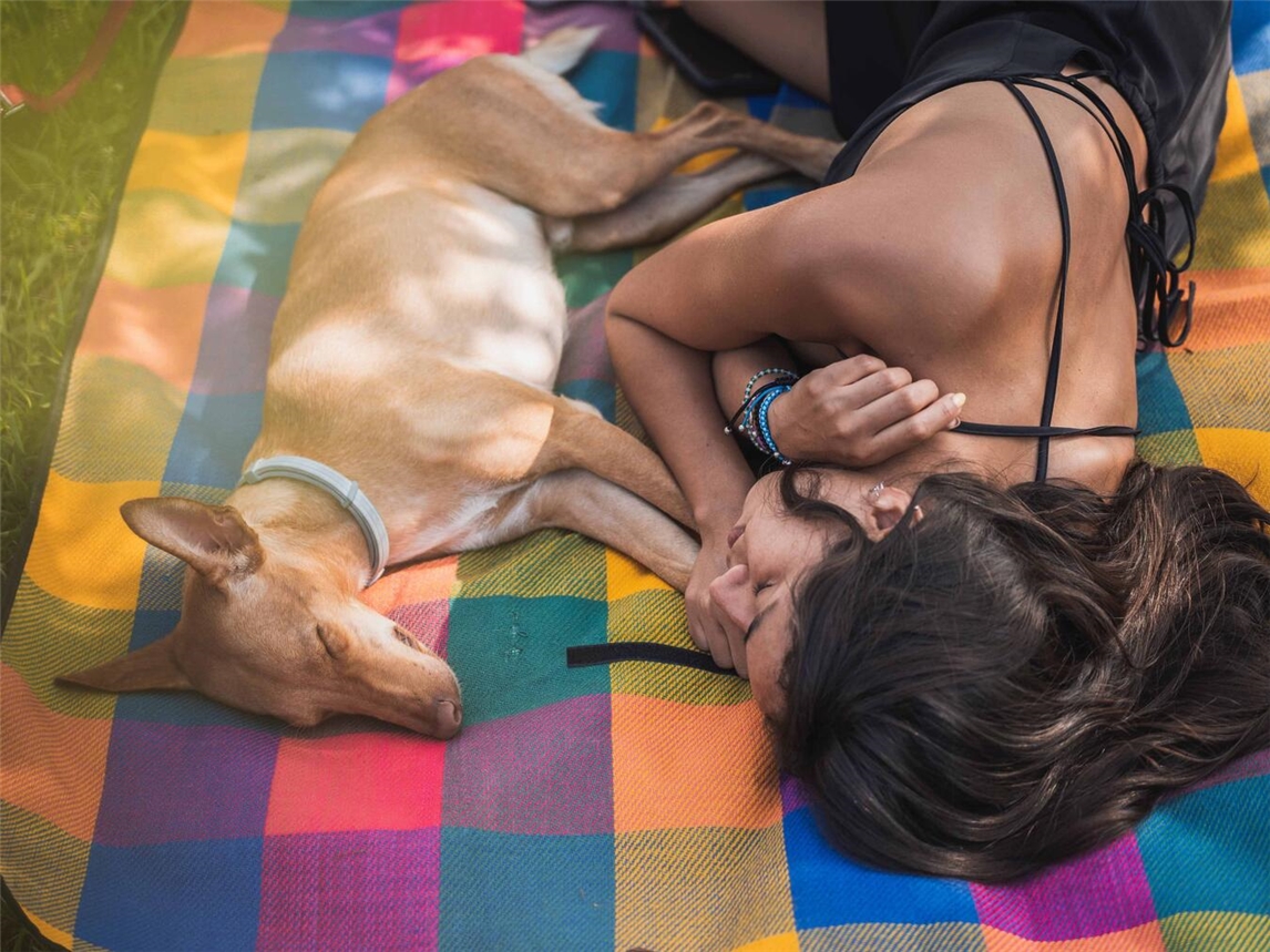 "Person genießt Frühlingssonne im Park, symbolisiert Übergang vom Winter zum Frühling, Energieauftanken, Erholung"