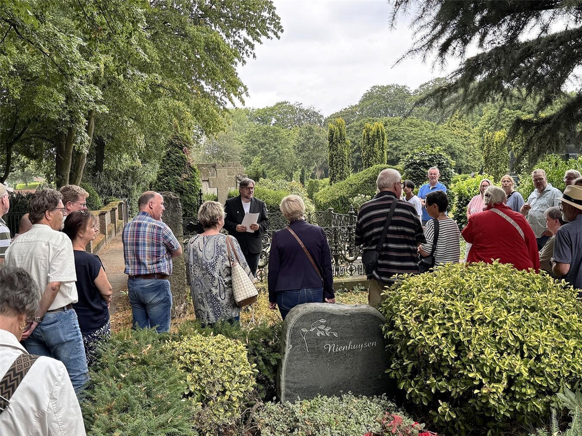 "Michael Scholten erklärt die Grabstele des Barons von Wissel und das Disch-Familiengrab auf historischem Friedhof."