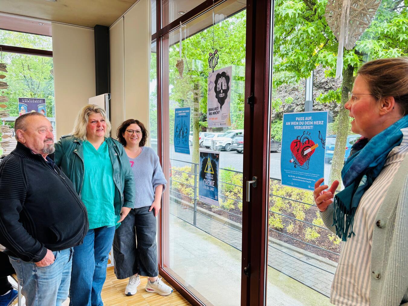 Im Kontaktcafé der Caritas ist die Plakatausstellung bereits zu sehen. Auf dem Bild zu sehen sind: Barbara Kortland (v.r.), Leiterin der Beratungsstelle für Suchtfragen, Jennifer Dellnitz von der Fachstelle für Suchtprävention, Astrid Martens vom Fachdienst Aufsuchende Hilfen sowie Georgij. Foto: Caritas Kleve