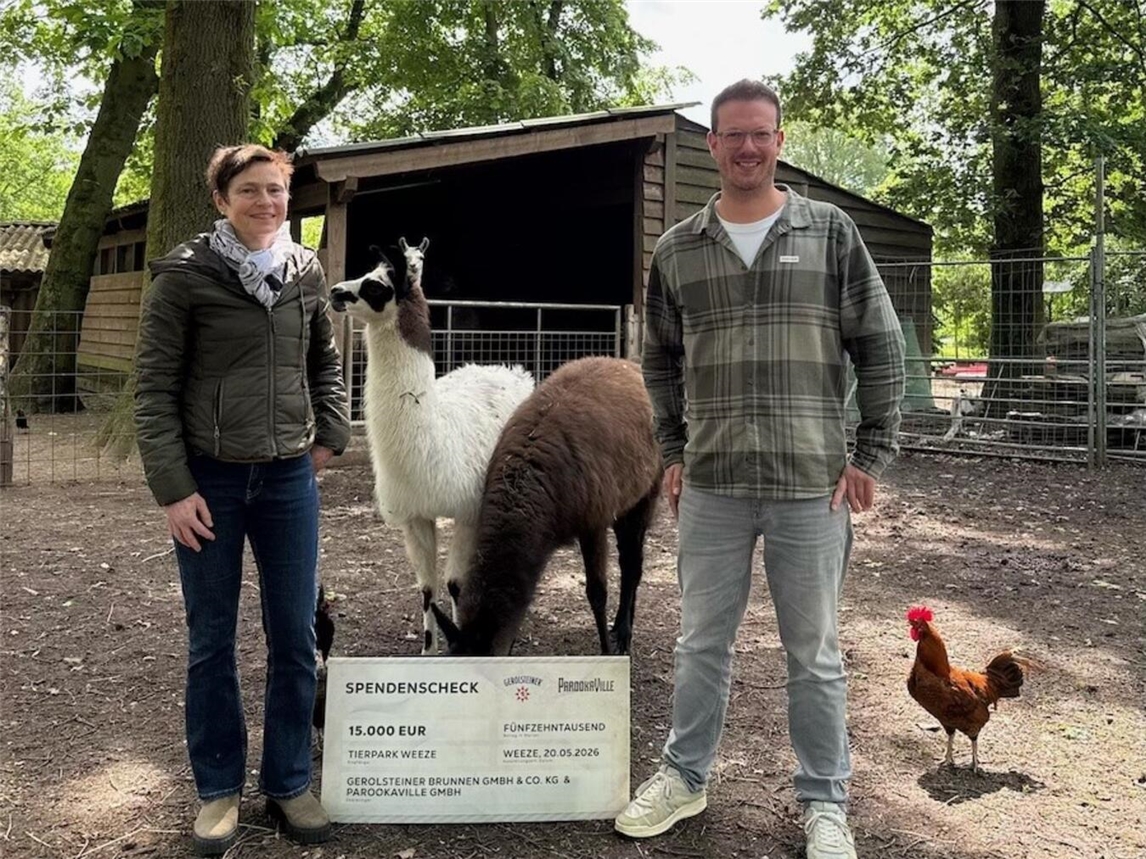 "Spendenübergabe: Parookaville übernimmt Lama-Patenschaft, Isabel Janowitz und Bernd Dicks mit Lama Bill im Tierpark Weeze."