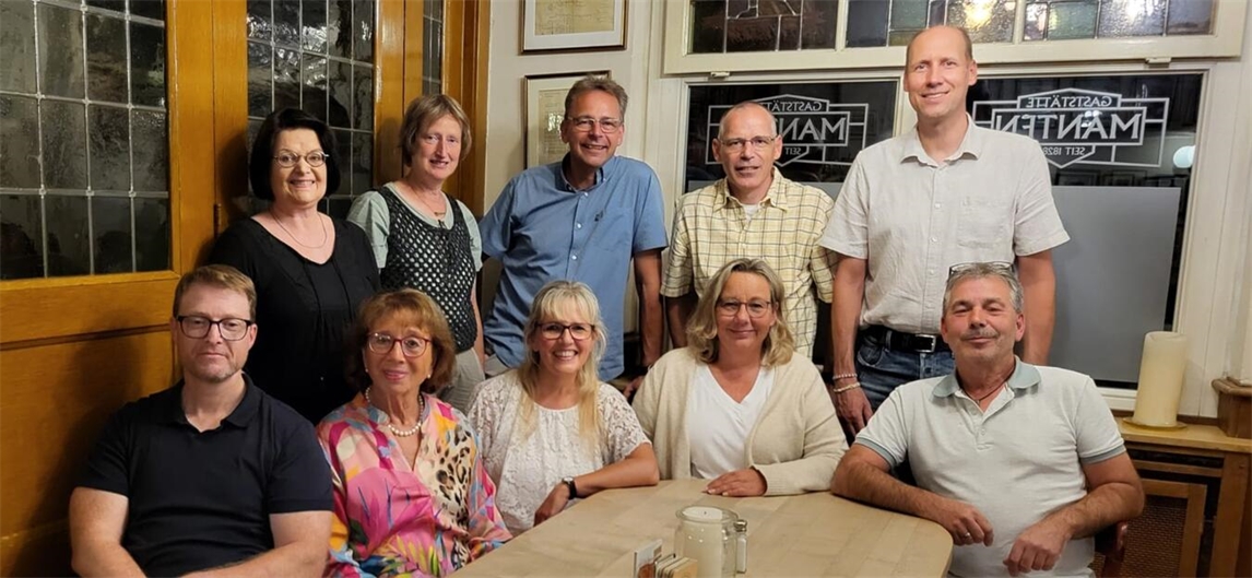 Klassentreffen in der Gaststätte Manten, fröhliche Menschen beim Wiedersehen, gemütliche Atmosphäre.