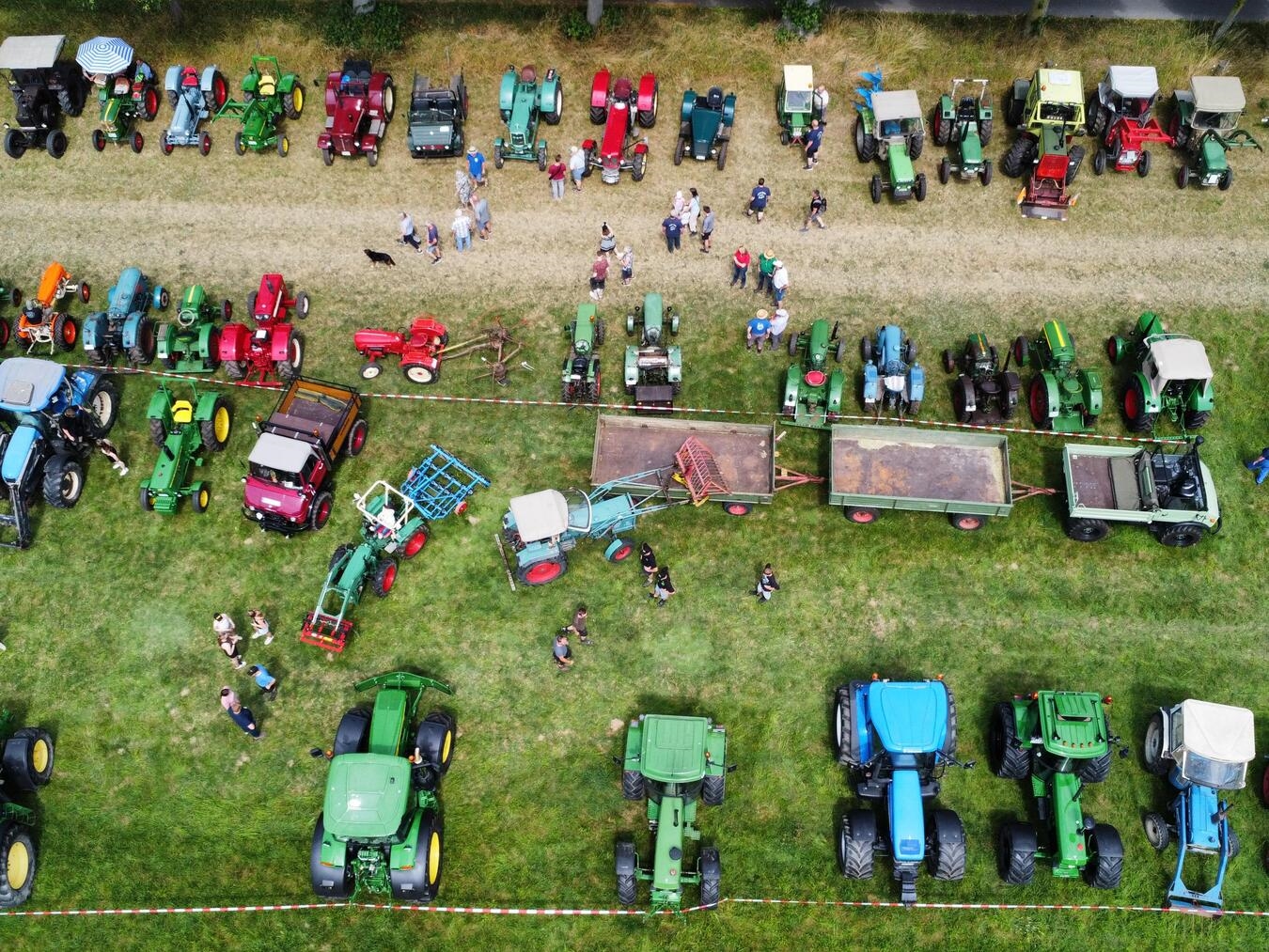 "Besucher bei Oldtimer-Treffen auf Wiese nahe Kirche, organisiert von Landmaschinenfreunden Louisendorf"