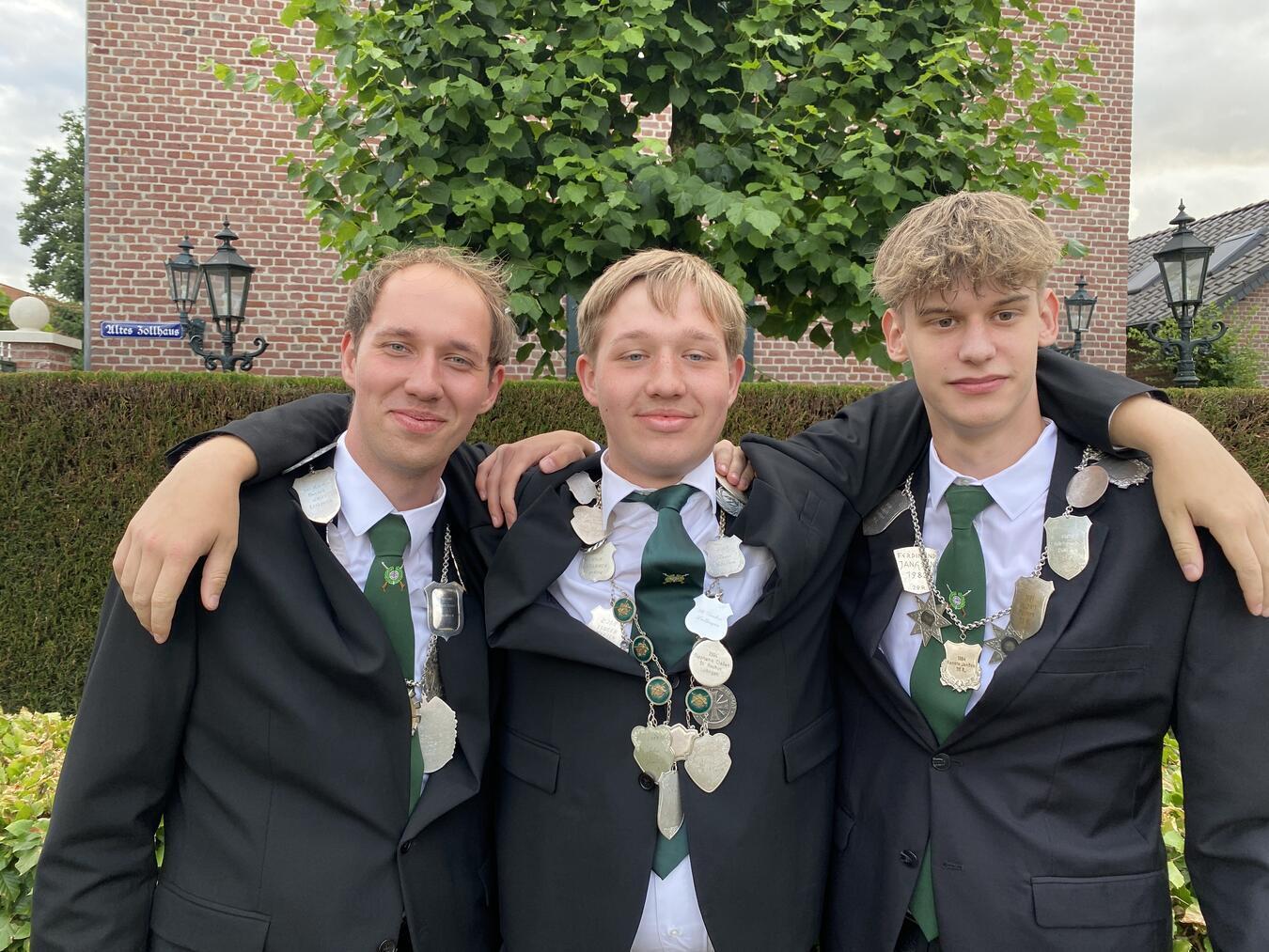 Feuerwehrfrau und -mann stellen das Königspaar Jens Küsters, Lukas Küsters und Noah Jeckstadt.