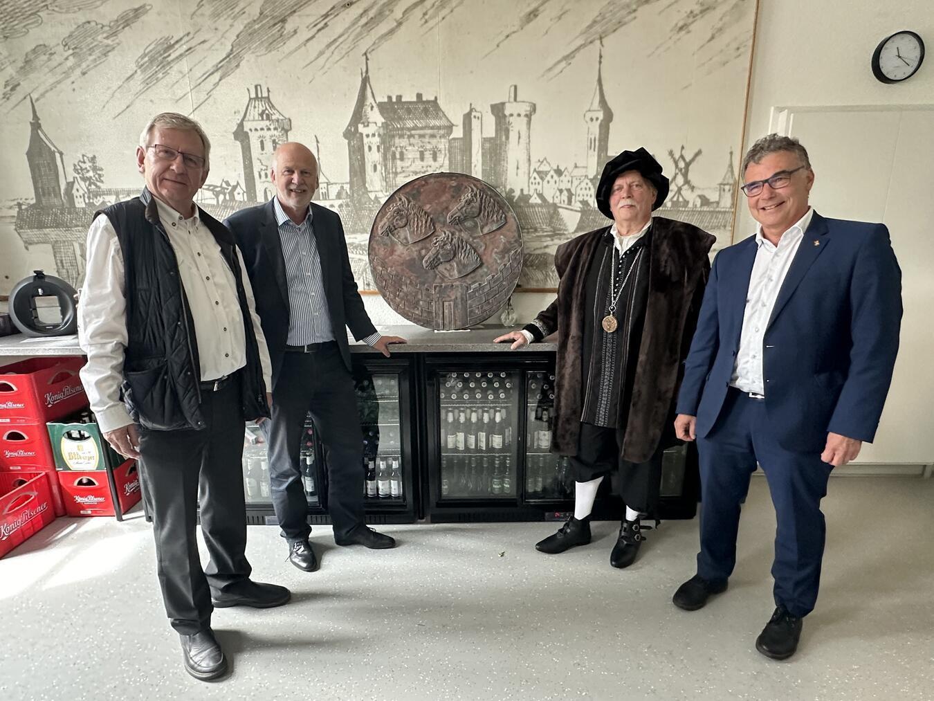 Josef Devers (Vorsitzender des Vereins), Rheinbergs Beigeordneter Dieter Paus, Bernie Abel und Bürgermeister Dietmar Heyde (v.l.) mit dem originalen Stadtwappen, das als Vorlage dienen soll. NN-Fotos (2): SP
