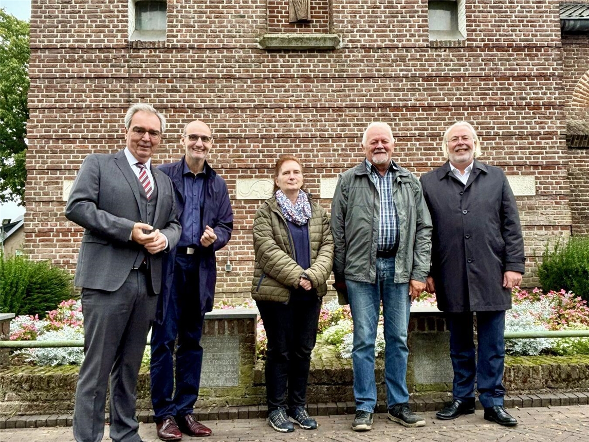 Josef Gietemann, Paul-Josef Heister, Silvia Luggenhölscher, Rainer van Hout und Ferdi Böhmer (v.l.) vor der Kirche von Breedeweg mit Blick auf das Relief „Toter Soldat“. Foto: Marco Cillessen