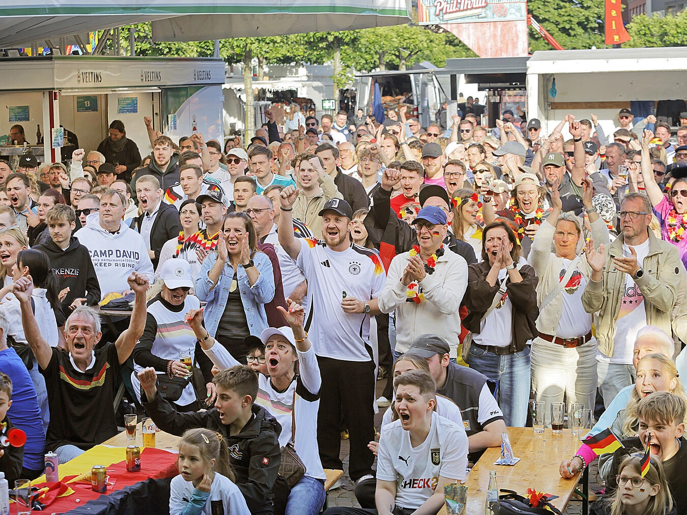 "Jubelnde Menschenmenge beim Public Viewing der WM auf Straßenparty, Foto von Theo Leie"