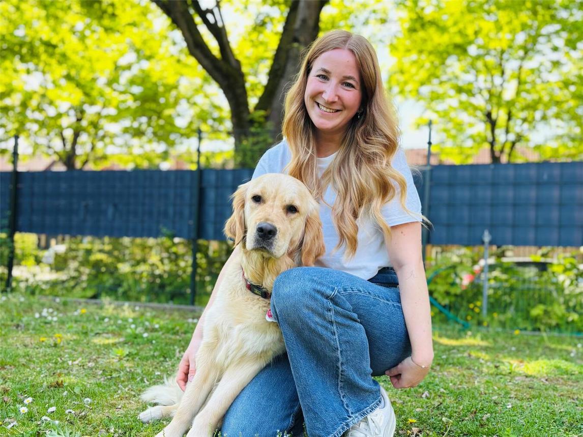 Jule Wolters mit ihrer Labrador-Hündin Abby im Garten der Tagesgruppe der Münze. Foto: Caritas