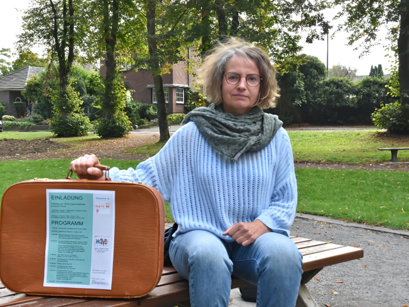 Jutta Seven, Diakonie-Mitarbeitende im Projekt „Endlich ein Zuhause“ mit einem Koffer - sinnbildlich das Hab und Gut wohnungsloser Menschen. Foto: privat