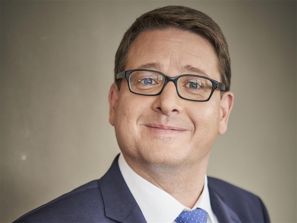 "Kai Magnus Sting lächelt in die Kamera, Porträtfoto von Guido Schroeder, Ankündigung für Auftritt in Issum am 16. Oktober"