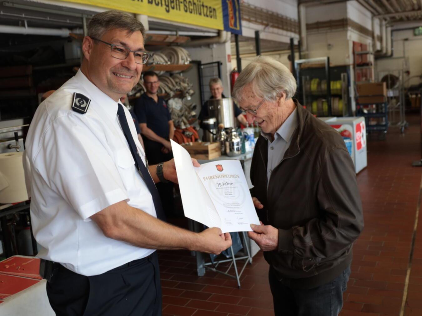 Karl Nielen erhält die Ehrenurkunde für 75 Jahre Mitgliedschaft von Ralf Benkel, Leiter der Feuerwehr Kleve. Foto: Feuerwehr Kleve