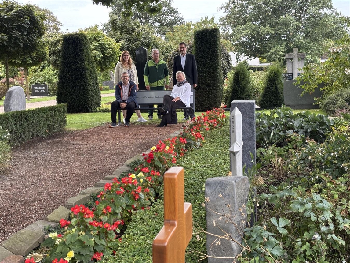 "Karla Cleven und Kollegen präsentieren neue Sitzbänke auf dem Friedhof in Issum, unterstützt von Bürgermeister Alexander Alberts."