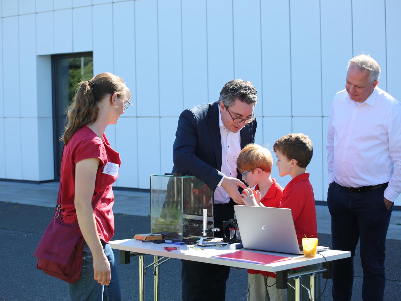Kinder zeigen MdB Stefan Rouenhoff (2. vl) und Professor Dr. Peter Kisters (r) Bodentiere unter der digitalen Lupe; im Bild Erzieherin Nadine Beck sowie Malte und Victor.